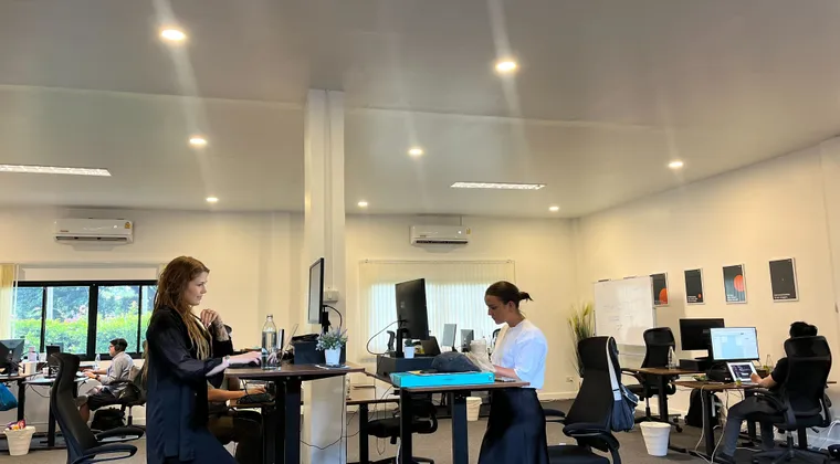 Azendo specialists working at standing desks in the Chiang Mai office