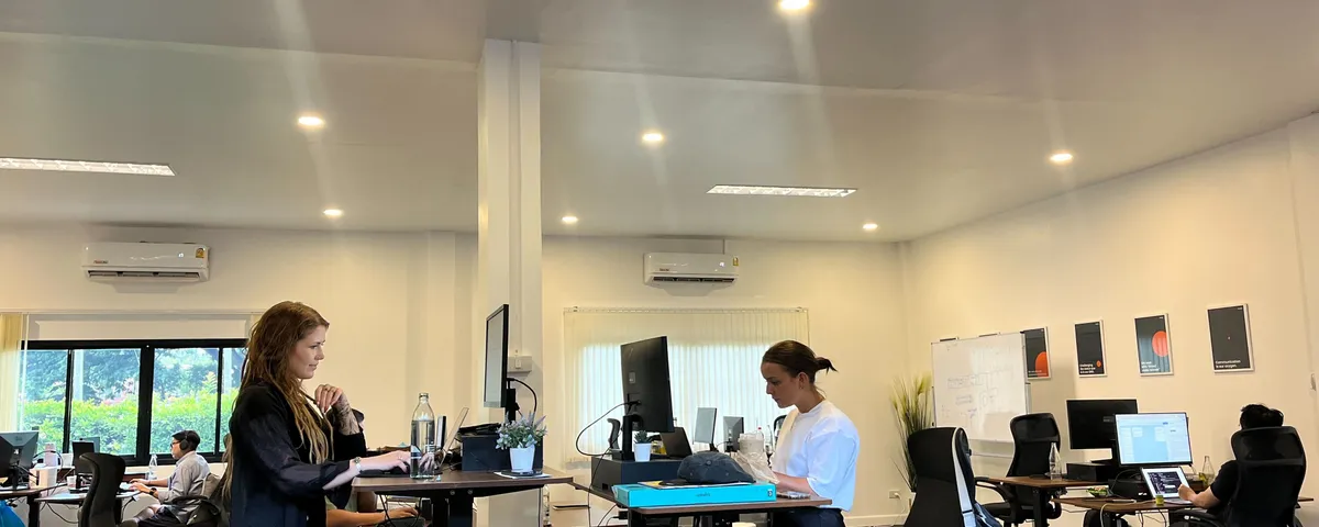 Azendo specialists working at standing desks in the Chiang Mai office